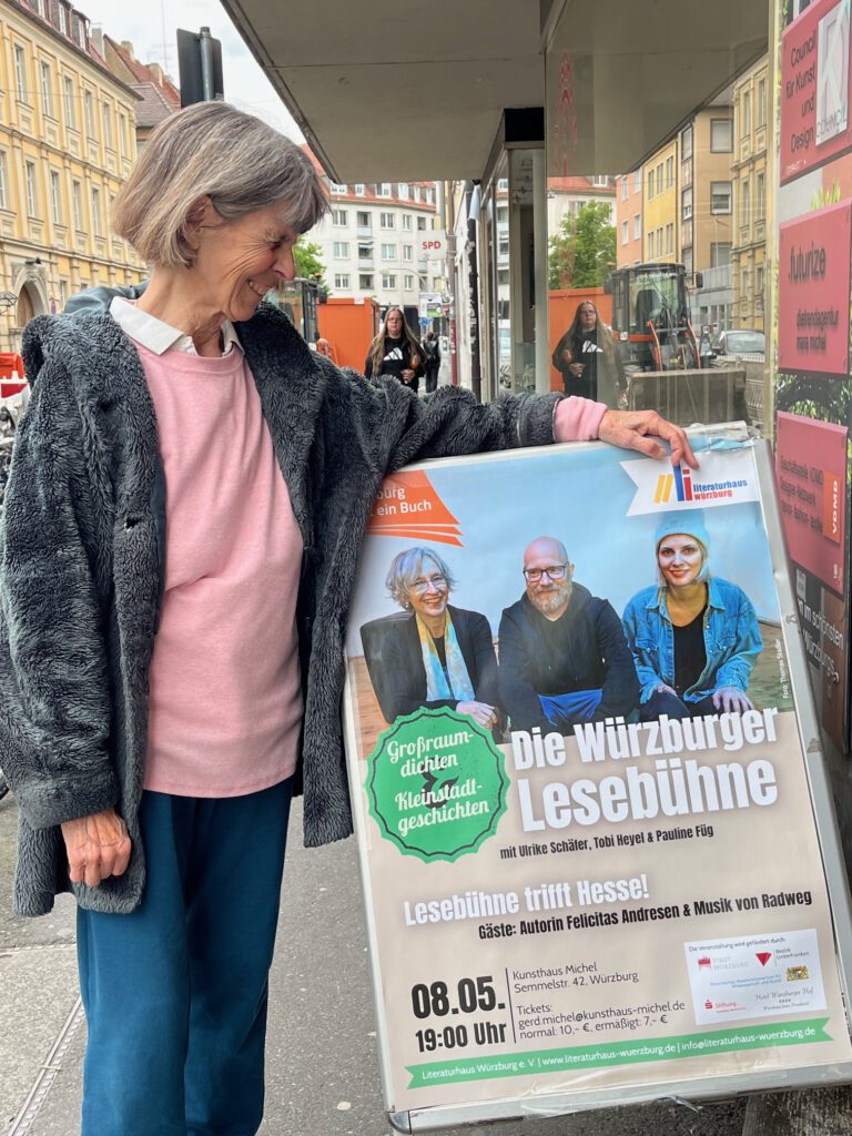 Felicitas Andresen mit einem Plakat von Großraumdichten-Kleinstadtgeschichten